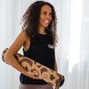 Model mit schwarzem Yoga-Top und Yogamatte aus Kork mit Leo Print, besides von Yoga Love Shop